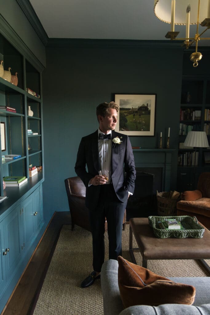 groom getting ready in dark green room at luxury estate wedding near Middleburg VA