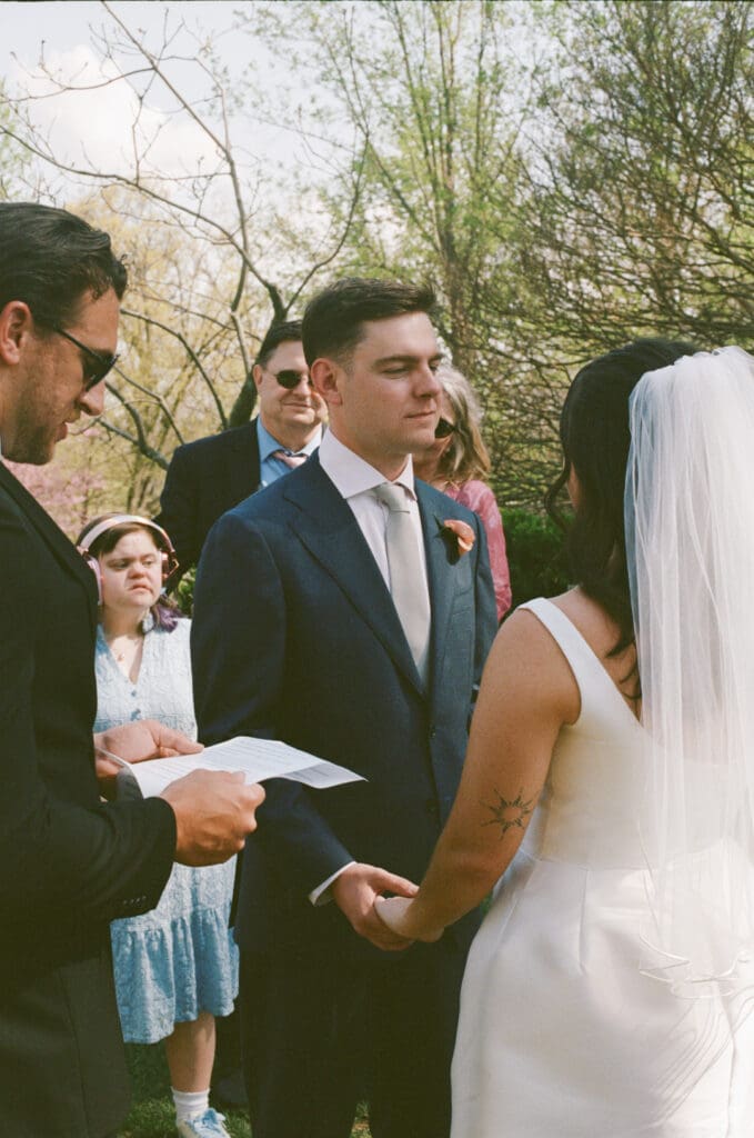 Couple holding hands during emotional ceremony officiated by best friend